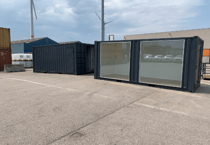 20 foot black custom shipping container modified into office work space with two large glass window for natural light with white walls by ContainerID 